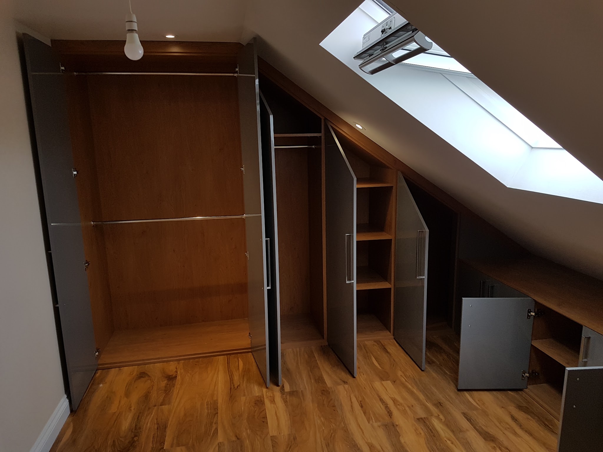 Built-in storage and shelves under a sloping loft ceiling