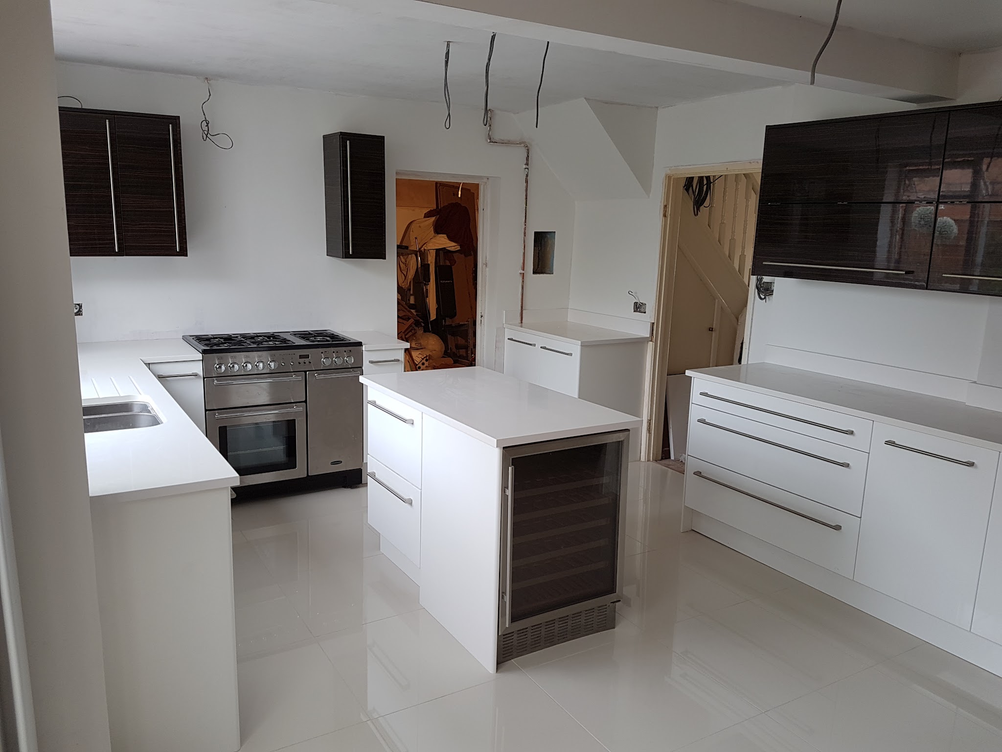 White kitchen with an island and range cooker, fitted by Carpentry & Joinery Service