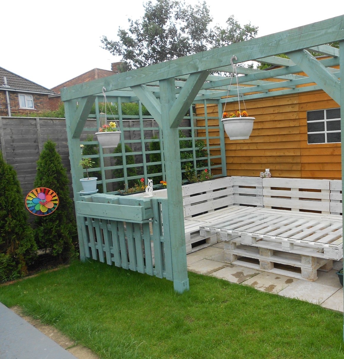 Painted timber pergola over a patio seating area
