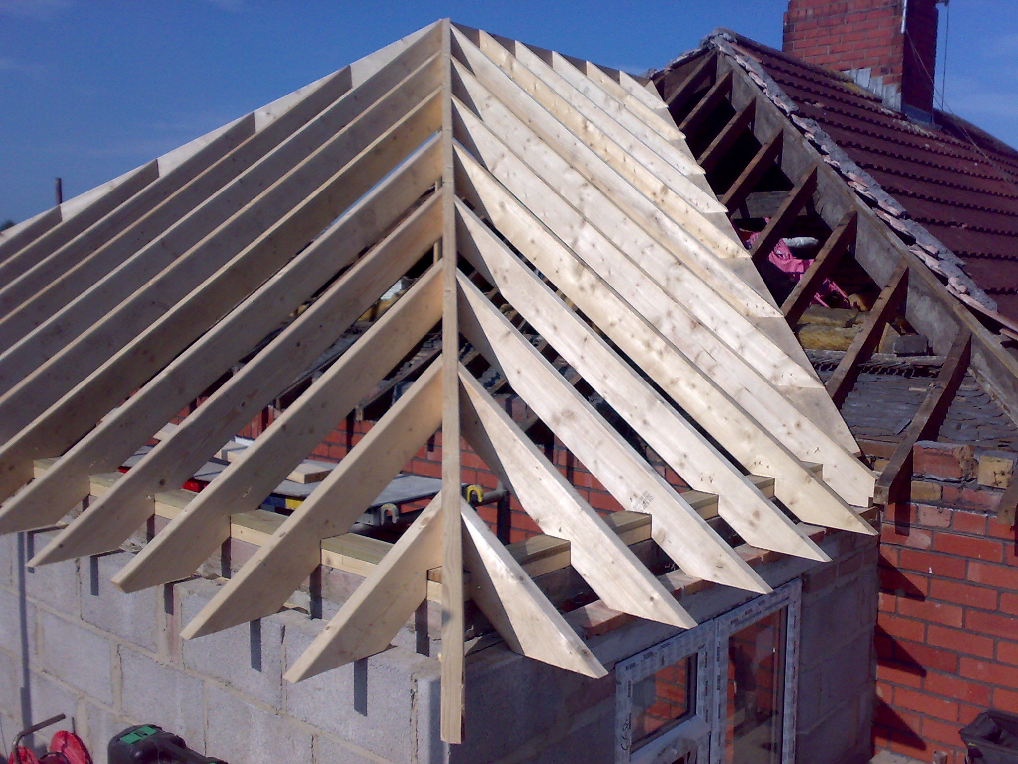 New hip roof rafters going up on a brick extension